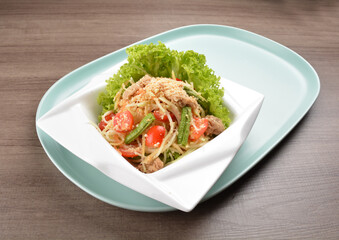 thai cold mango papaya vegetable salad in spicy sour lime sauce on wood background asian halal vegan menu