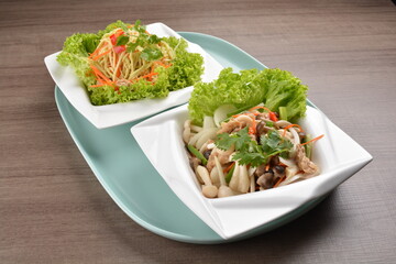 thai cold papaya mango and mushroom vegetable salad in spicy sour lime sauce on wood background asian halal vegan menu
