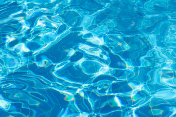 Plakat Hotel pool with sun reflections. Summer vacation concept. Surface of azure swimming pool. Top view rippled blue pool water with copy space.