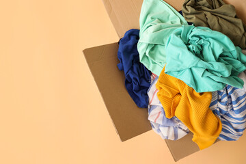 Wardrobe box with clothes on color background