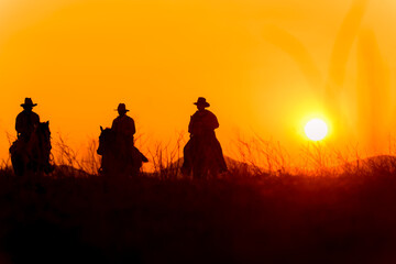 Fototapeta na wymiar Cowboy silhouette riding a horse When the sunset looks beautiful 