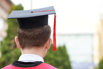 Male graduating student outdoors, back view
