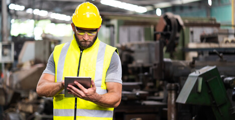 Man at work. Mechanical Engineer  man in Hard Hat Wearing Safety Jacket working in Heavy Industry Manufacturing Facility. Professional Engineer Operating lathe Machinery