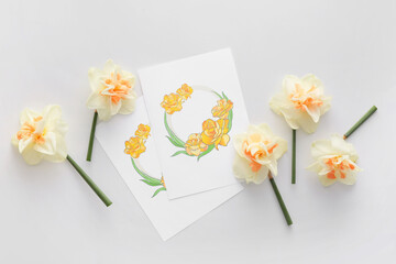 Beautiful daffodils and greeting cards on white background
