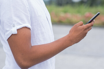 Close up of hands of African American man with a smartphone. Freelance, working, touching, typing