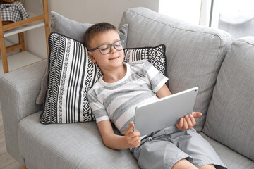 Cute boy watching cartoons at home