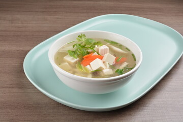 healthy white bean curd tofu and mixed vegetable hot soup on wood background asian halal vegan menu