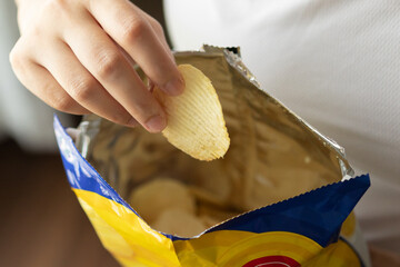 Hand hold potato chips with snack bag