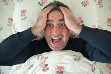 Mature adult man waking up with brilliant idea in bed