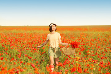 Fototapeta premium Beautiful young woman in poppy field