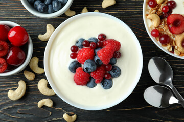 Concept of tasty breakfast with yogurt on wooden table