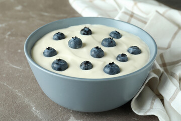 Concept of tasty breakfast with yogurt on gray textured table