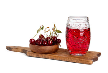 Board with glass of sweet cherry wine on white background