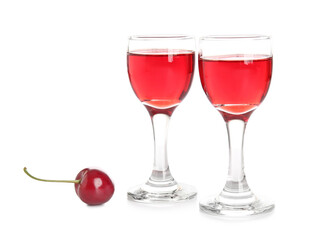Glasses of sweet cherry wine on white background