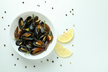 Plate with fresh mussels on white background