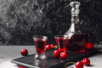 Composition with glasses of sweet cherry wine on dark background