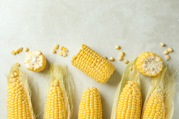 Fresh raw corn on white textured background, top view