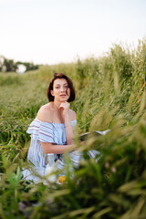 Beautiful young woman in summer in a wheat field