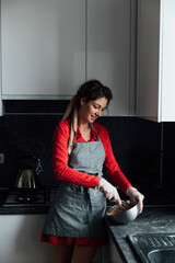 beautiful woman cooks sweet delicious dessert in the kitchen