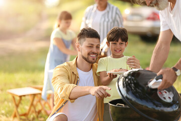 Happy family at barbecue party on summer day