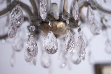 Details on a beautiful antique chandelier hanging from a living door or a ballroom lobby ceiling