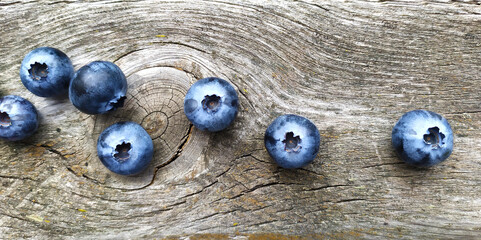 Fresh ripe blueberries on old wooden board. Berry background. Stock macro horizontal photo fresh blueberry under the sunshine, outdoors, wooden background