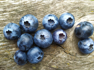 Fresh ripe blueberries on old wooden board. Berry background. Stock macro photo fresh blueberry under the sunshine, outdoors, wooden background