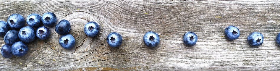 Fresh ripe blueberries on old wooden board. Berry background. Stock macro photo fresh blueberry under the sunshine, outdoors horizontal photo