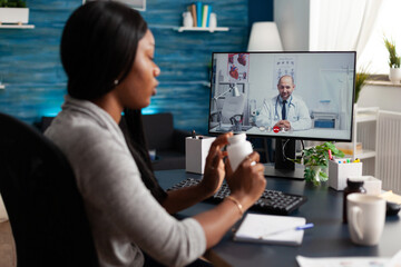 Black patient discussing pills treatment with physician doctor during online videocall meeting conference. African american student having respiratory sickness. Therapist explaining test results