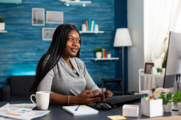 African student holding credit card in hands doing online transcation searching shop store using digital gadget. Teenager browsing internet banking service on computer sitting at desk in living room