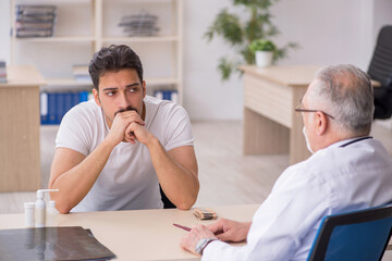 Young male patient visiting old male doctor