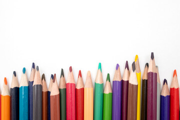 Multi-colored pencils row on a white background