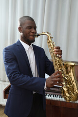 Obraz premium African-American man playing saxophone indoors. Talented musician