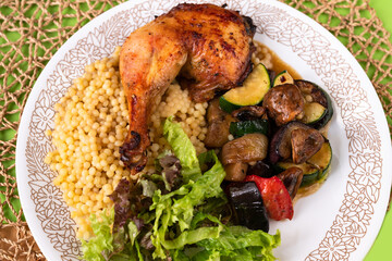 Chicken leg with fried vegetable , salad leaf and pasta