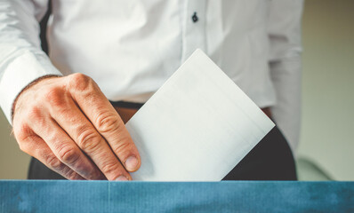 male hand putting vote in ballot