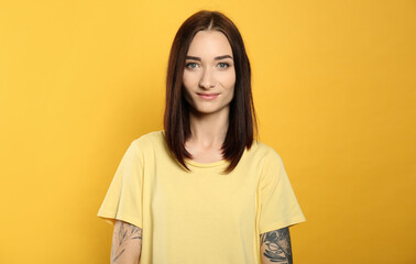Obraz premium Portrait of pretty young woman with gorgeous chestnut hair on yellow background