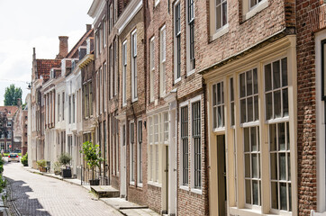 Fototapeta na wymiar Middelburg, the Netherlands, July 25, 2021: picturesque street with brick facades in the old town on a sunny day