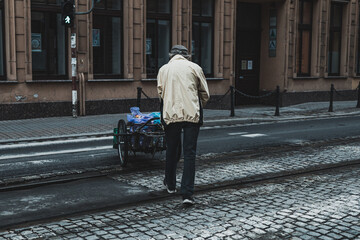 man pushing a cart with loads, street photography