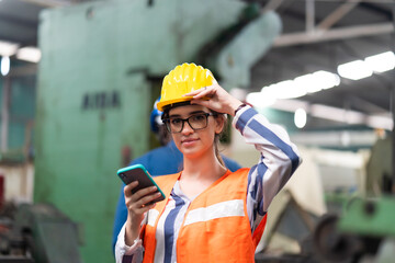 Female Quality control inspector checking workers at factory. Engineering Worker team working in Heavy Industry Manufacturing Facility.