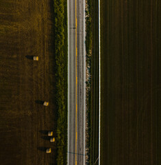 A bird's-eye view of an empty road, which is located next to the field. High quality photo