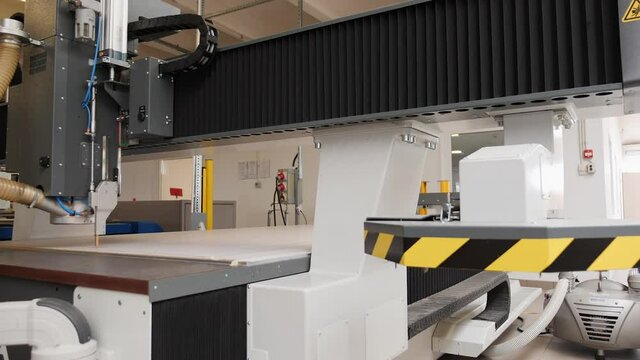 Industrial plotter working on large paper sheet - low angle, wide shot