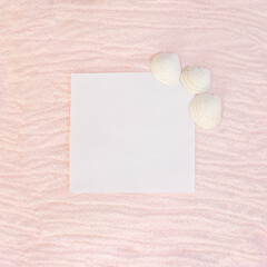 sandy flat lay copy space with pastel pink beige background and white space in the middle.sunny day summer concept with sea shells