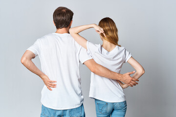 man and woman in white t-shirts stand with their backs design studio
