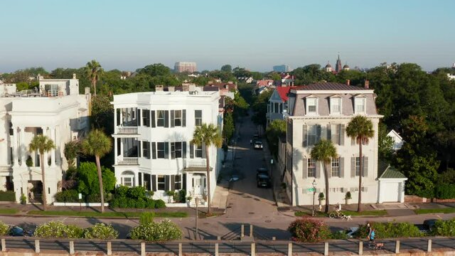 Rising aerial at Battery in Charleston SC. People run, walk exercise, ride bike. Historic homes.