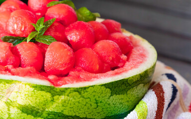 sweet and juicy watermelon small balls and mint salad, served using the skin as a bowl. Summer food concept. Selective focus. Close up