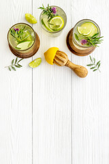 Fresh cold beverage with summer herbs and lemon in glasses