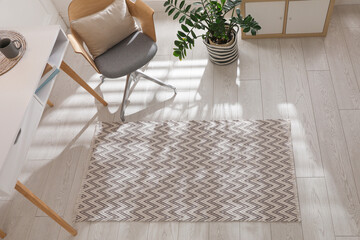 Stylish rug with pattern on floor in room, above view