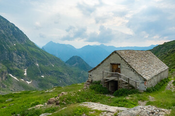 Fototapeta na wymiar View from Alpe Scaredi in the Val Grande National Park over the barn into the inner valley and surrounding mountains