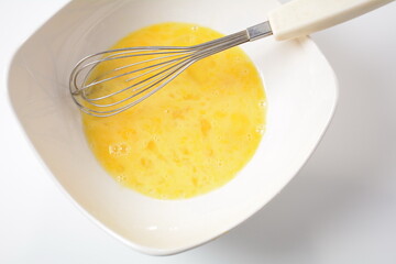 Proсess  of cooking Omelette  . Beaten egg yolks in a bowl with whisk