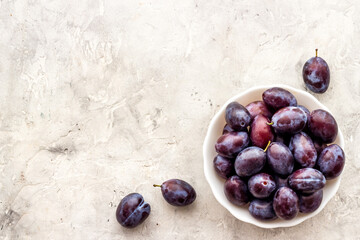 Food layout with plums in bowl with leaves. Top view